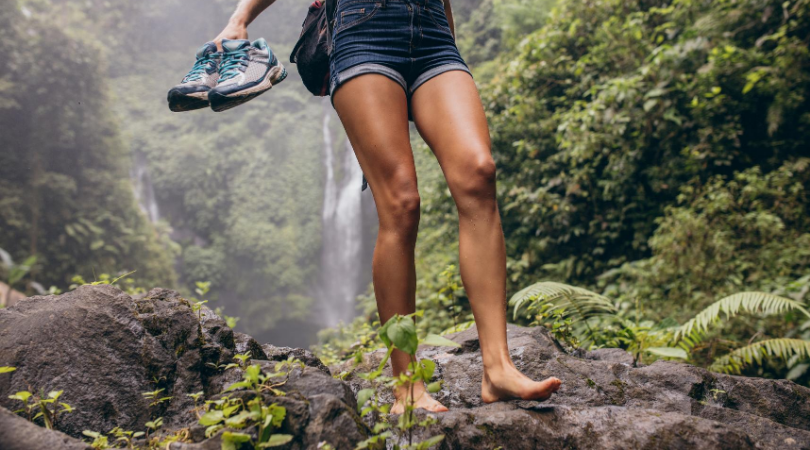 Runner walking in bare feet while holding shoes
