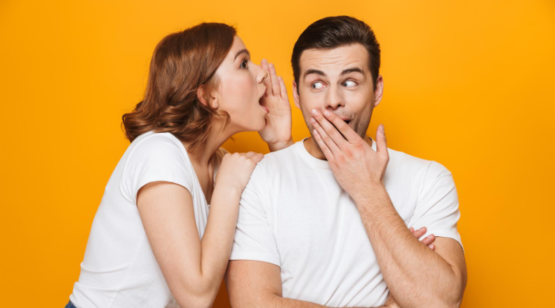 picture of a women whispering into a mans ear