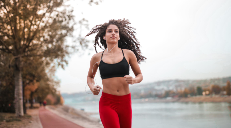 confident runner running beside a lake