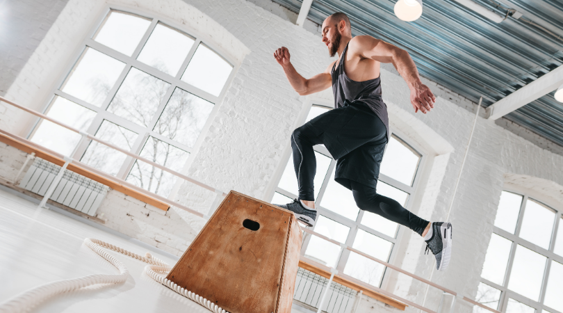 runner doing box jumps in the gym