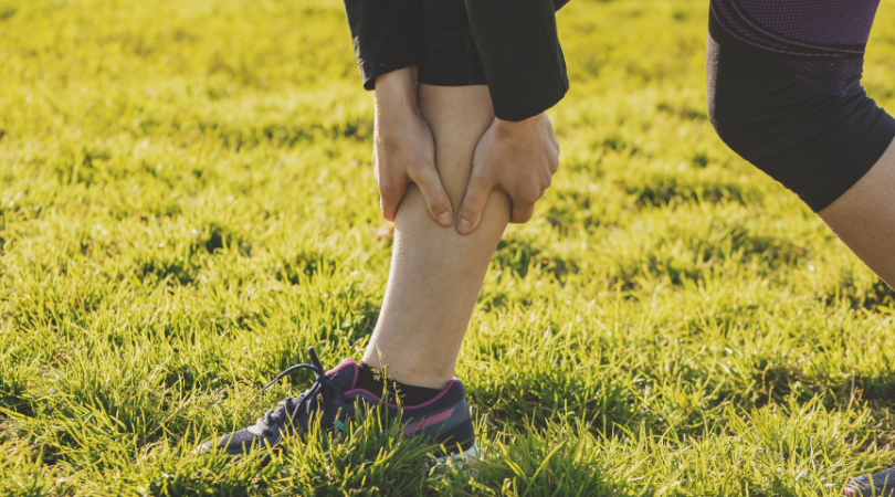 runner holding her shin in pain